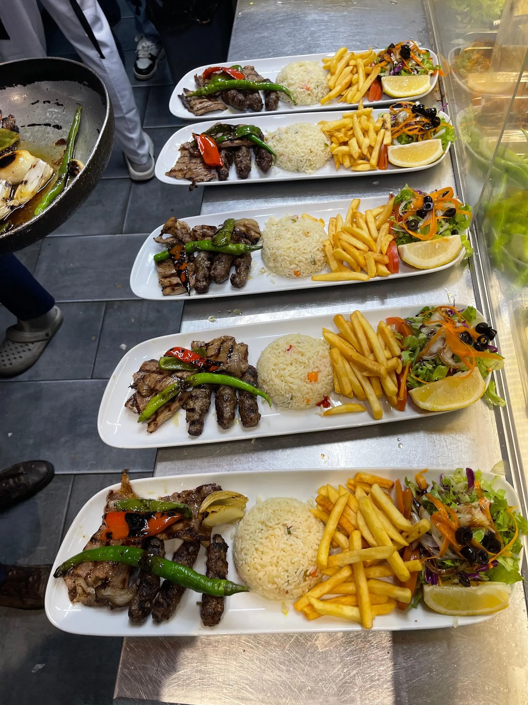 Pratos de grelhados turcos com arroz, batatas fritas, salada e malagueta