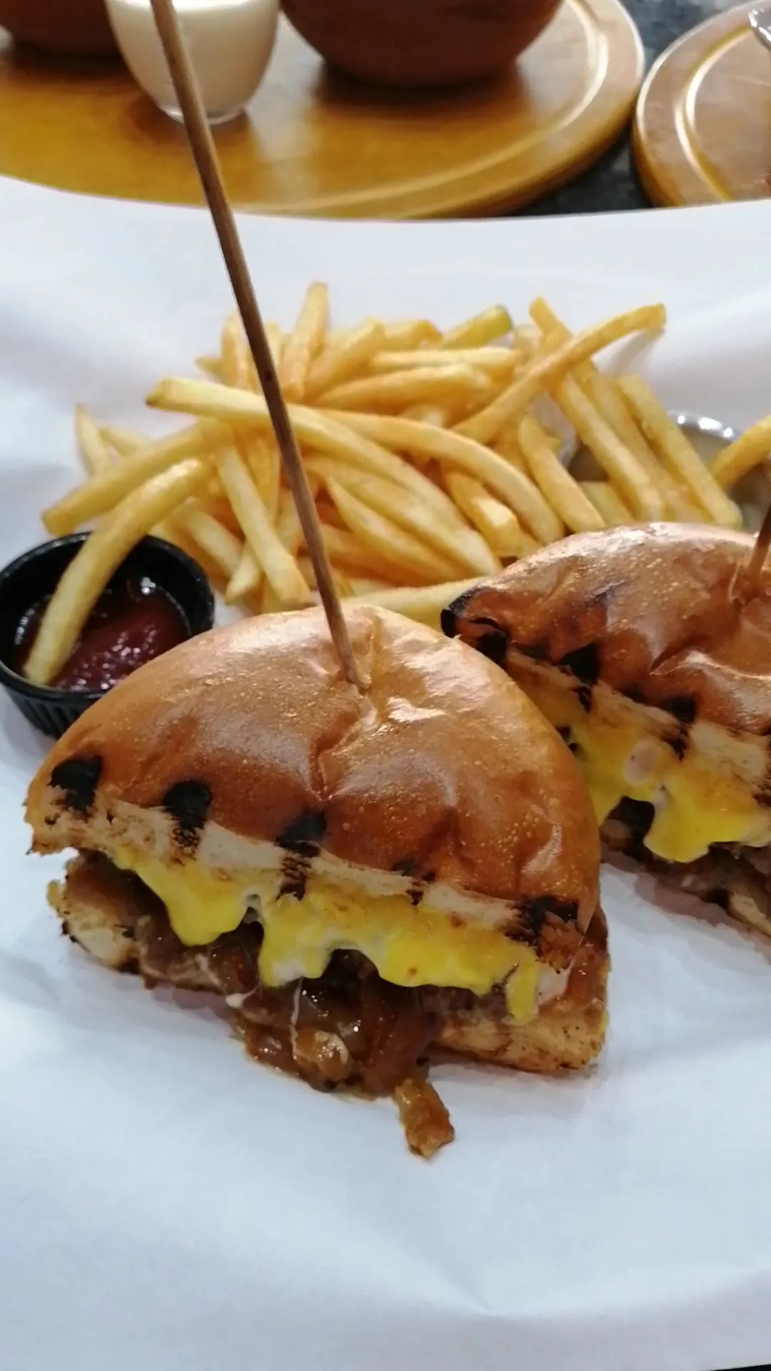 Hambúrguer cortado ao meio com batatas fritas
